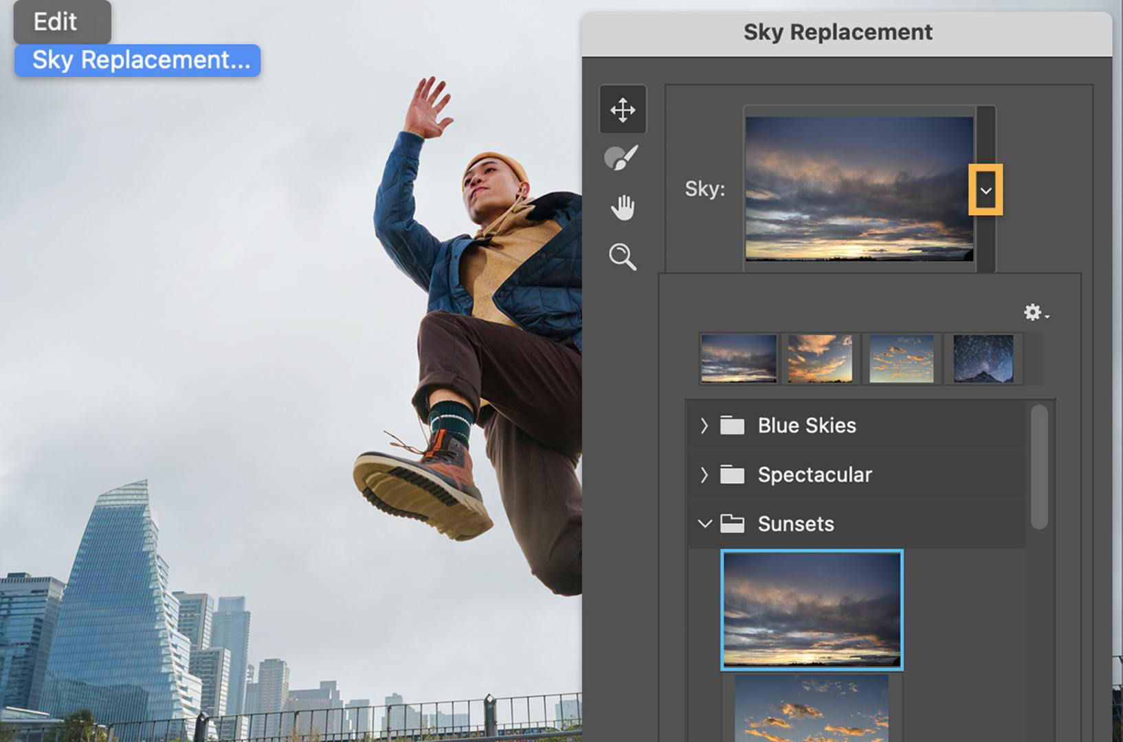 A man jumps with a gray sky behind him. The Sky Replacement panel shows a gallery of skies with a cloudy, dusk sky selected.