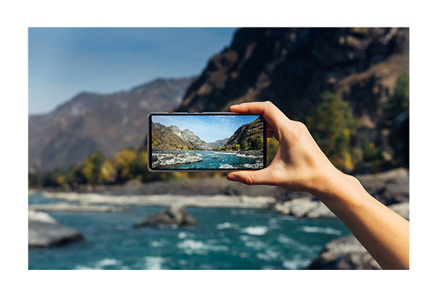 Photo of someone taking a photo of the ocean with their mobile phone