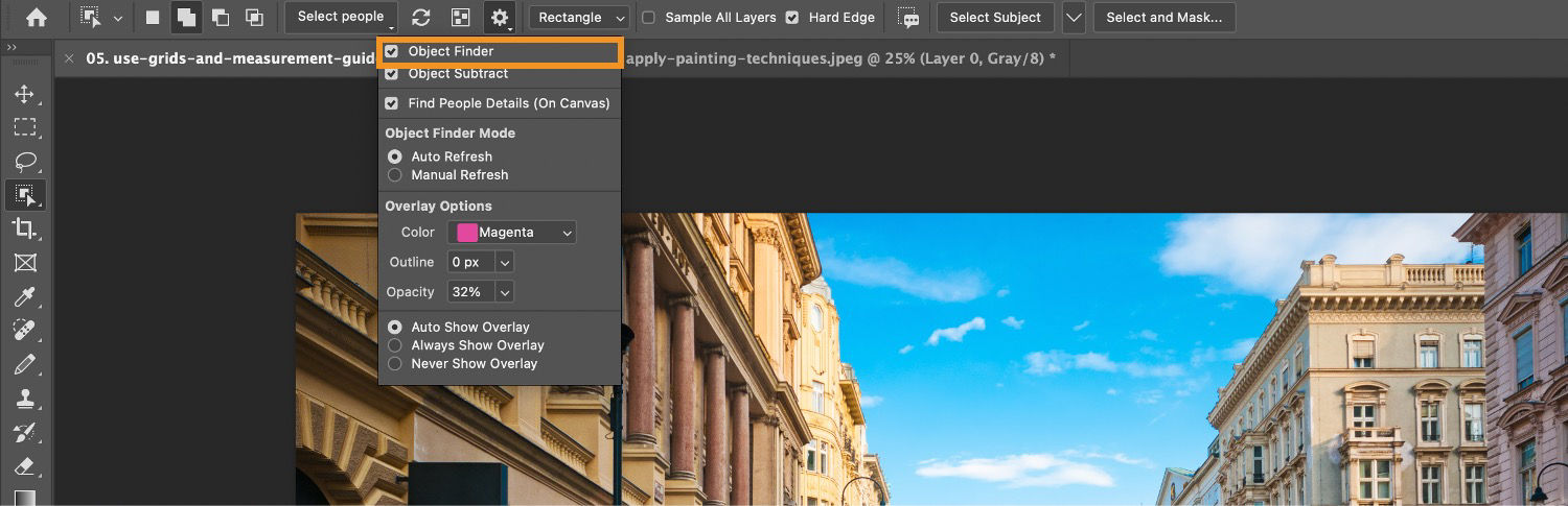 Object finder is highlighted in the settings menu of the Object Selection tool in the Options bar, above an image of buildings on the Photoshop canvas.