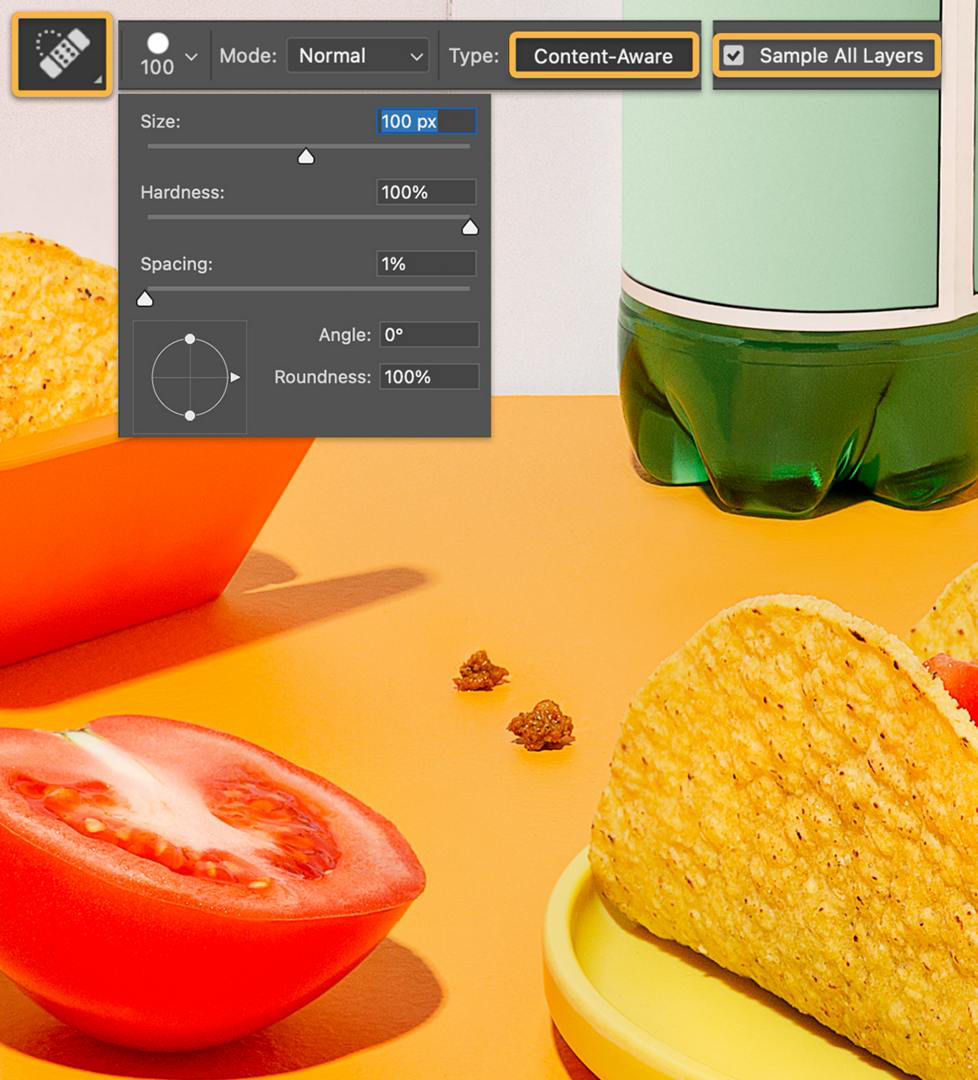 The Spot Healing Tool icon, which is a bandaid, is shown and the Content Aware and Sample All Layers options are highlighted in the Options bar.