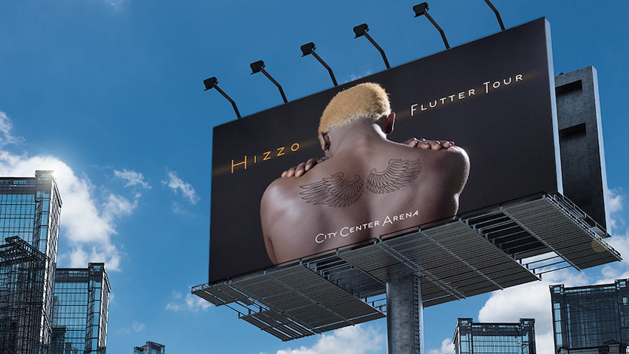 Billboard for music tour features a man’s back tattooed with wings. 