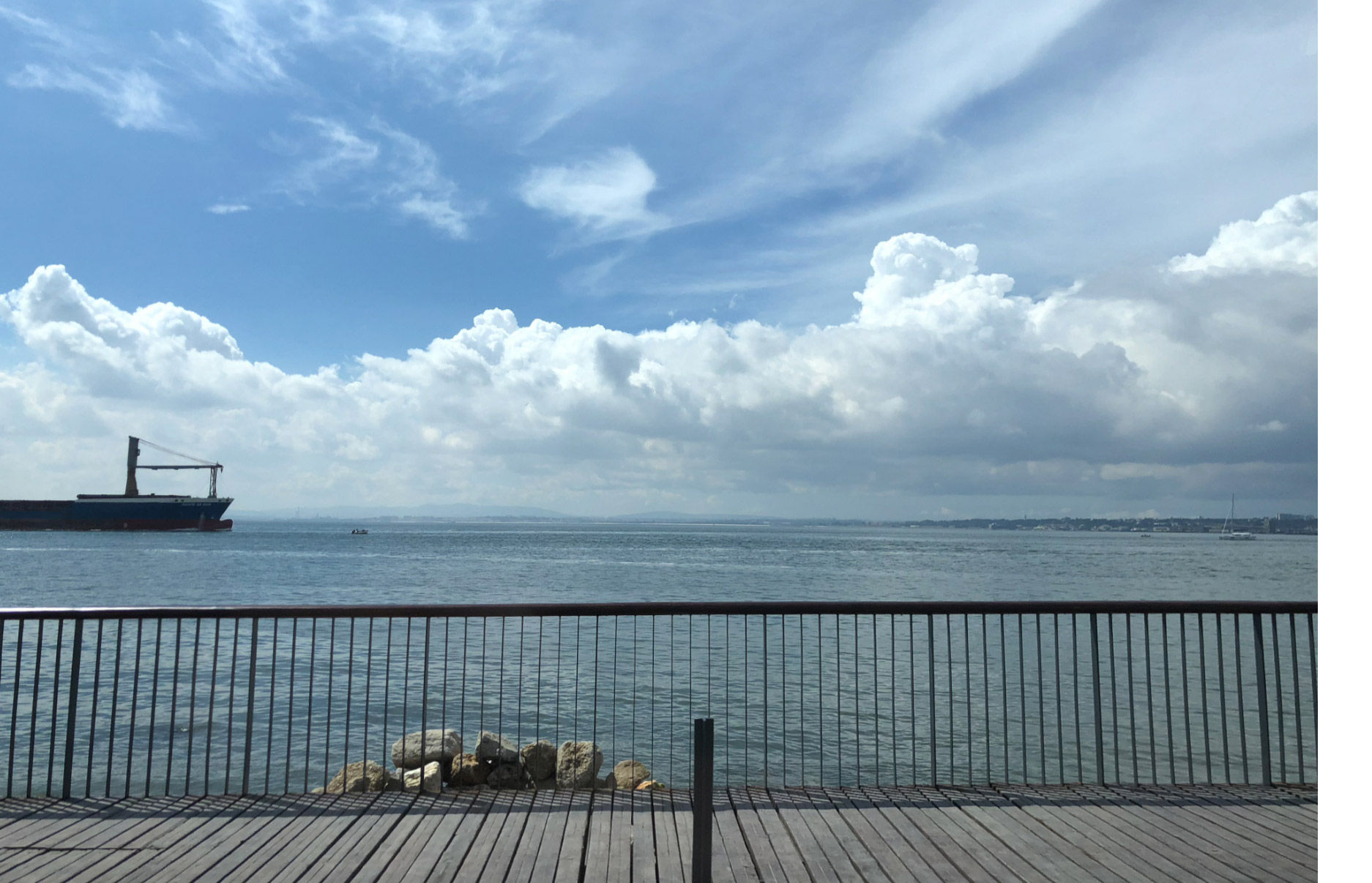 Ocean photo featuring light blue sky with wispy clouds.