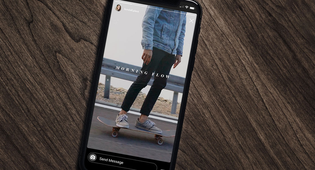 Cell phone on wood table shows a skateboarder on the screen, Adobe Premiere logo is lower left