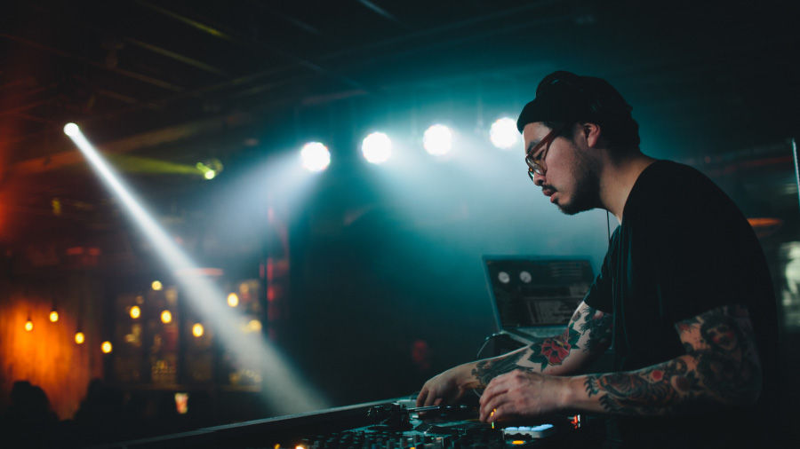 An image of a DJ onstage with dramatic color and lighting effects