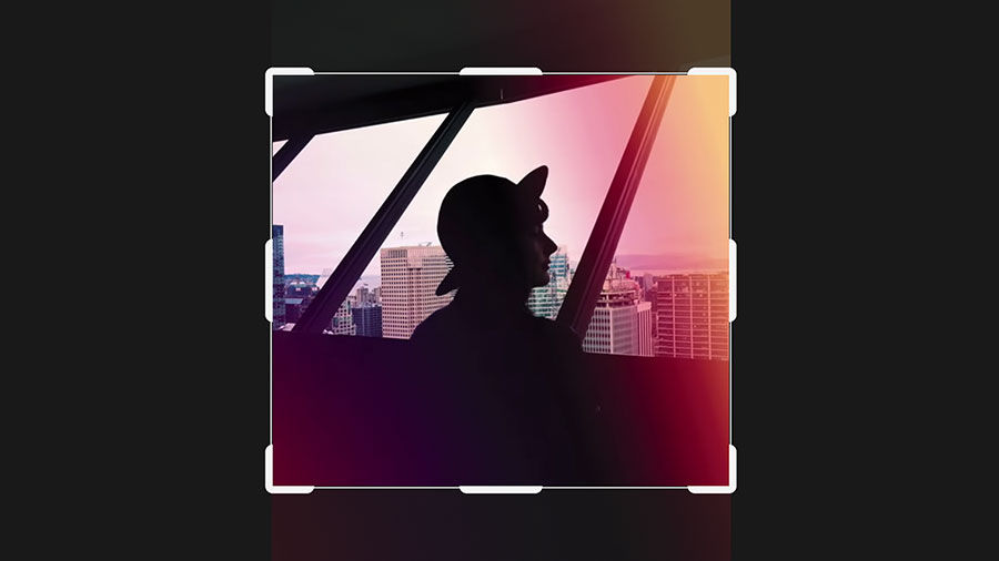 Image of a woman above a cityscape on a black background with crop marks around the photo border