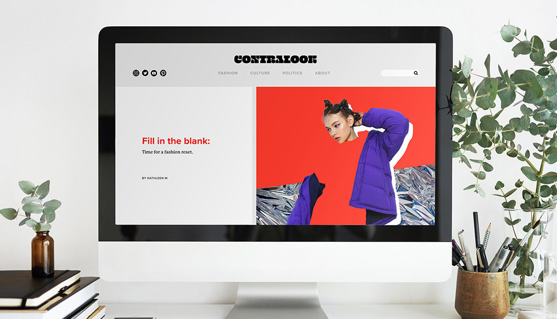 Computer monitor on desk shows magazine layout with cutout collage on lower right