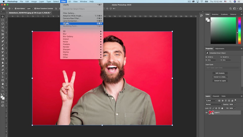 Photoshop workspace with the Filter > Liquify menu highlighted while the selected artwork displays a man making a peace sign on a red background  