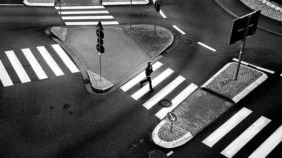 Black and white overhead image of a person in a crosswalk