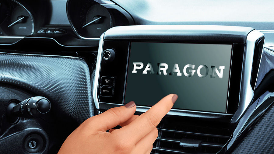 A woman’s hand points at a digital dashboard screen starting up, which displays a shiny metallic logo: the word ‘PARAGON’