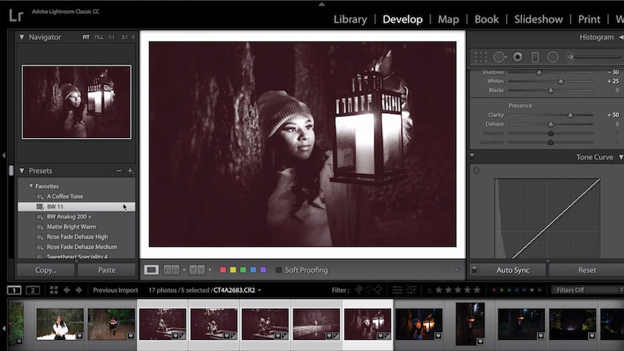 Young woman holding lantern is converted to a black and white image with red undertones 