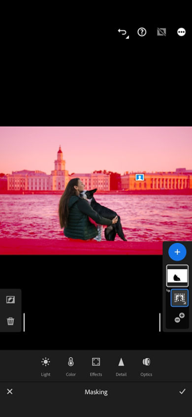  A lady with the dog is sitting on the river bank where masking is applied on the background and Masking panel is opened with local adjustment at the bottom.