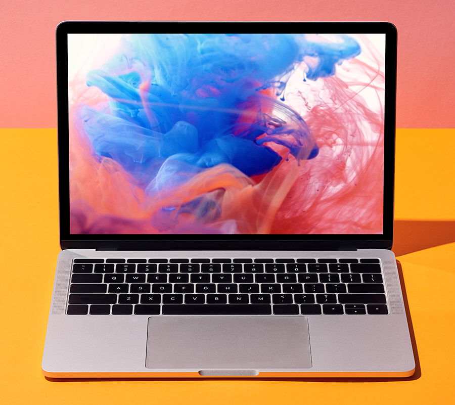 Static shot of blue and red ink mixing together displays on laptop placeholder set against a pink and yellow background.