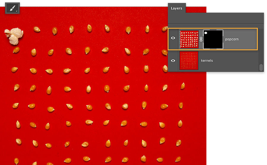 1 kernel of popcorn on red background is popped, remaining kernels are un popped, layer mask shows white area where popped kernel was revealed.