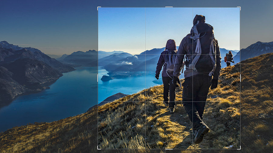 Photo of hikers on a trail overlooking a river with a section of the image highlighted with crop borders