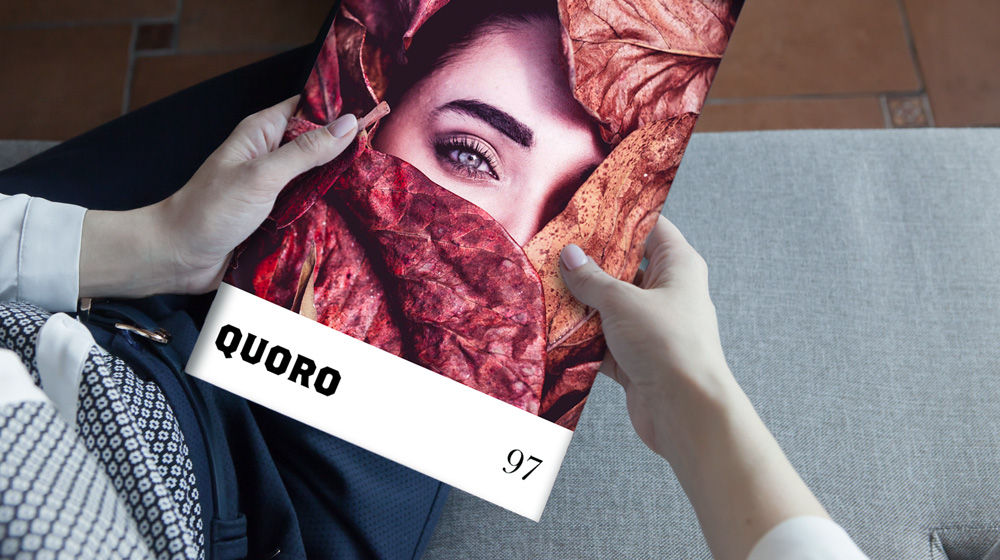 Man holding magazine. Cover shows leaves over a woman's face.