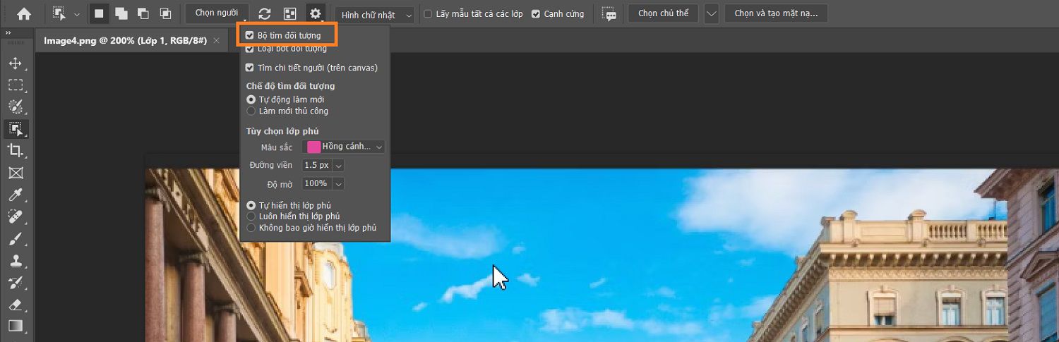 Công cụ tìm đối tượng được làm nổi bật trong menu cài đặt của công cụ Chọn đối tượng trong thanh tùy chọn, phía trên hình ảnh các tòa nhà trên canvas Photoshop.