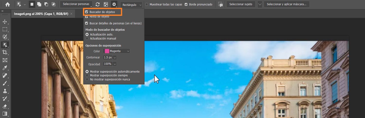 El buscador de objetos está resaltado en el menú de Configuración de la Herramienta Selección de objetos en la barra de options, sobre una imagen de edificios en el lienzo de photoshop.
