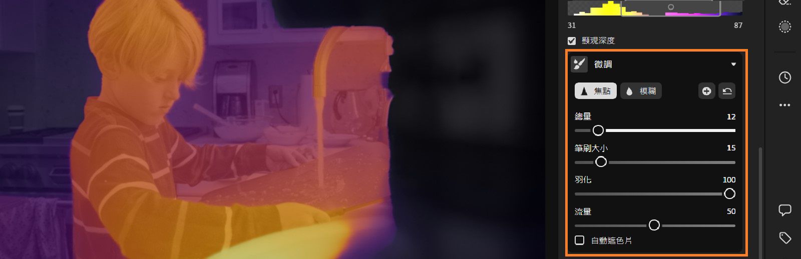 影像顯示一台電腦螢幕，並開啟「鏡頭模糊」的微調介面。螢幕的主要部分顯示出在廚房水槽前孩子的景深對應。顏色範圍從紫色到橙色，代表不同的景深對應。在螢幕右側有個工具列，內含各種滑桿和選項，例如「微調」、「焦點」、「模糊」等，並提示可調整影像的景深和焦點。 