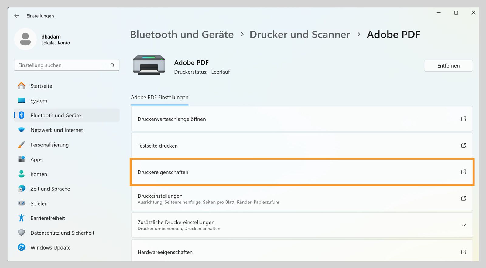 Das Fenster „Einstellungen“ in Windows 11 zeigt Adobe PDF-Druckereinstellungen wie Druckwarteschlange öffnen, Druckereigenschaften, Druckeinstellungen und mehr. 