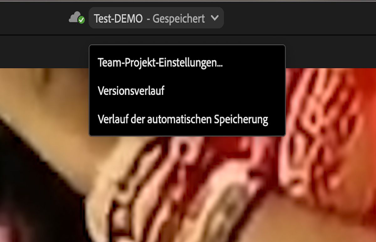 Die Benutzeroberfläche zeigt die Team Projects-Einstellungen, den Versionsverlauf und den automatischen Speicherverlauf direkt über die Premiere Pro-Kopfzeile auf.