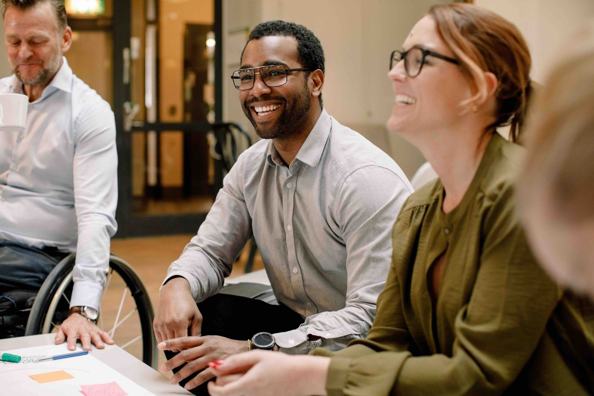 Tre professionisti in riunione. Il gruppo sembra molto coinvolto e sorridente, suggerendo un ambiente positivo e collaborativo.