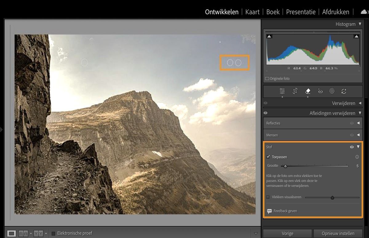 Een afbeelding van een berg met gemarkeerde stofvlekken door de camerasensor is geopend in Lightroom Classic met het paneel Afleidingen verwijderen.De Stof-functie verwijdert deze sensorkrassen.