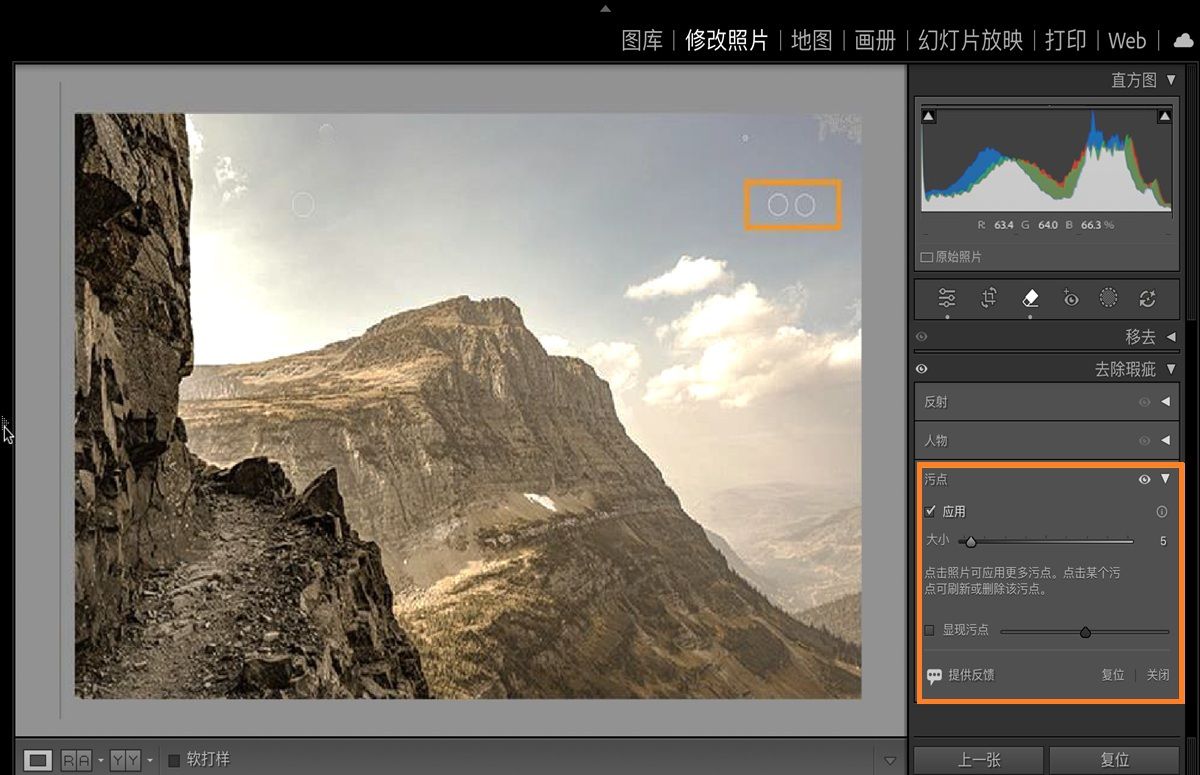 在 Lightroom Classic 中打开了一张带有由于相机传感器导致的灰尘高亮显示的山景图像，并且打开了“去除瑕疵”面板。使用除尘功能可以移除这些传感器灰尘斑点。