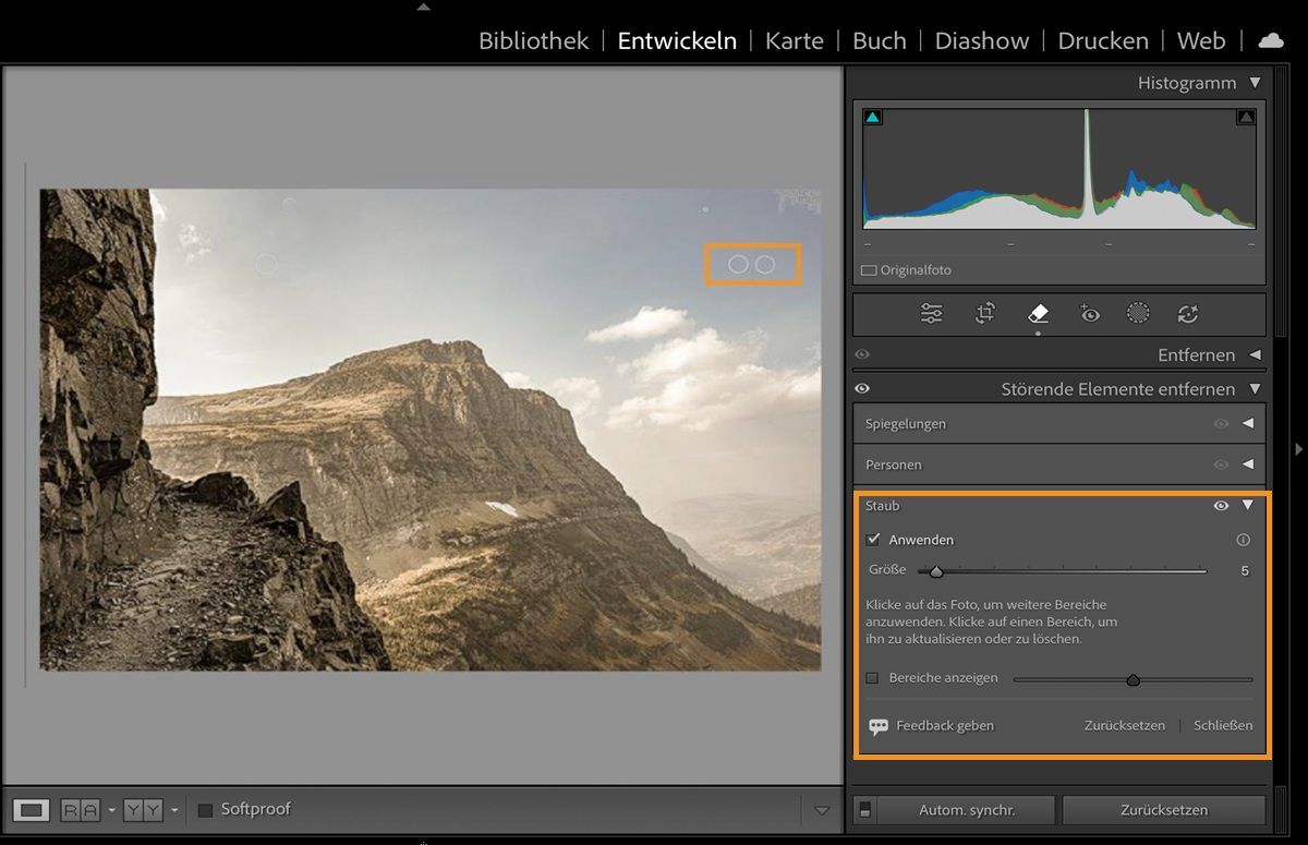 Bild eines Berges, auf dem die Staubflecken des Kamerasensors hervorgehoben werden, wird in Lightroom Classic geöffnet, während das Bedienfeld „Ablenkungsentfernung“ geöffnet ist. Die Staub-Funktion entfernt diese Sensorstaubflecken. 