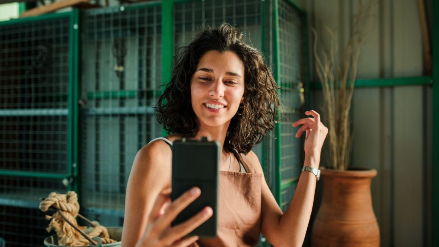 A small business content creator engaging with her followers on social media using her phone