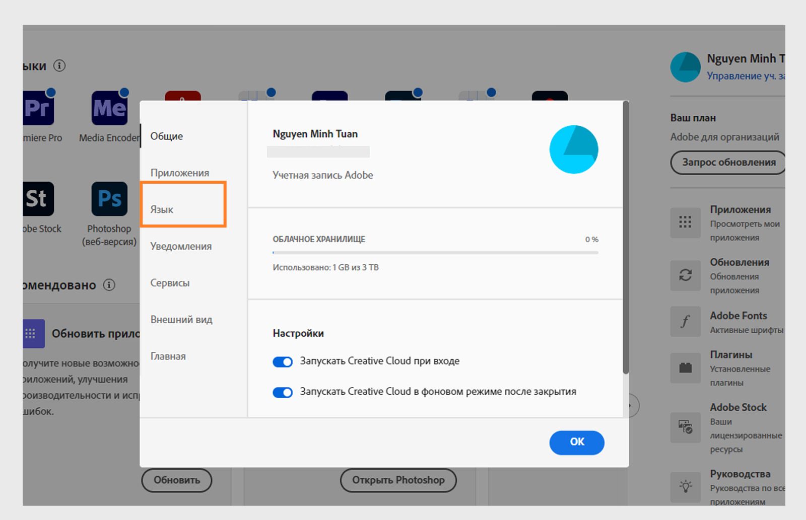 Панель настроек Adobe Creative Cloud открыта на вкладке "Язык", где выделена опция установки языка приложения по умолчанию.