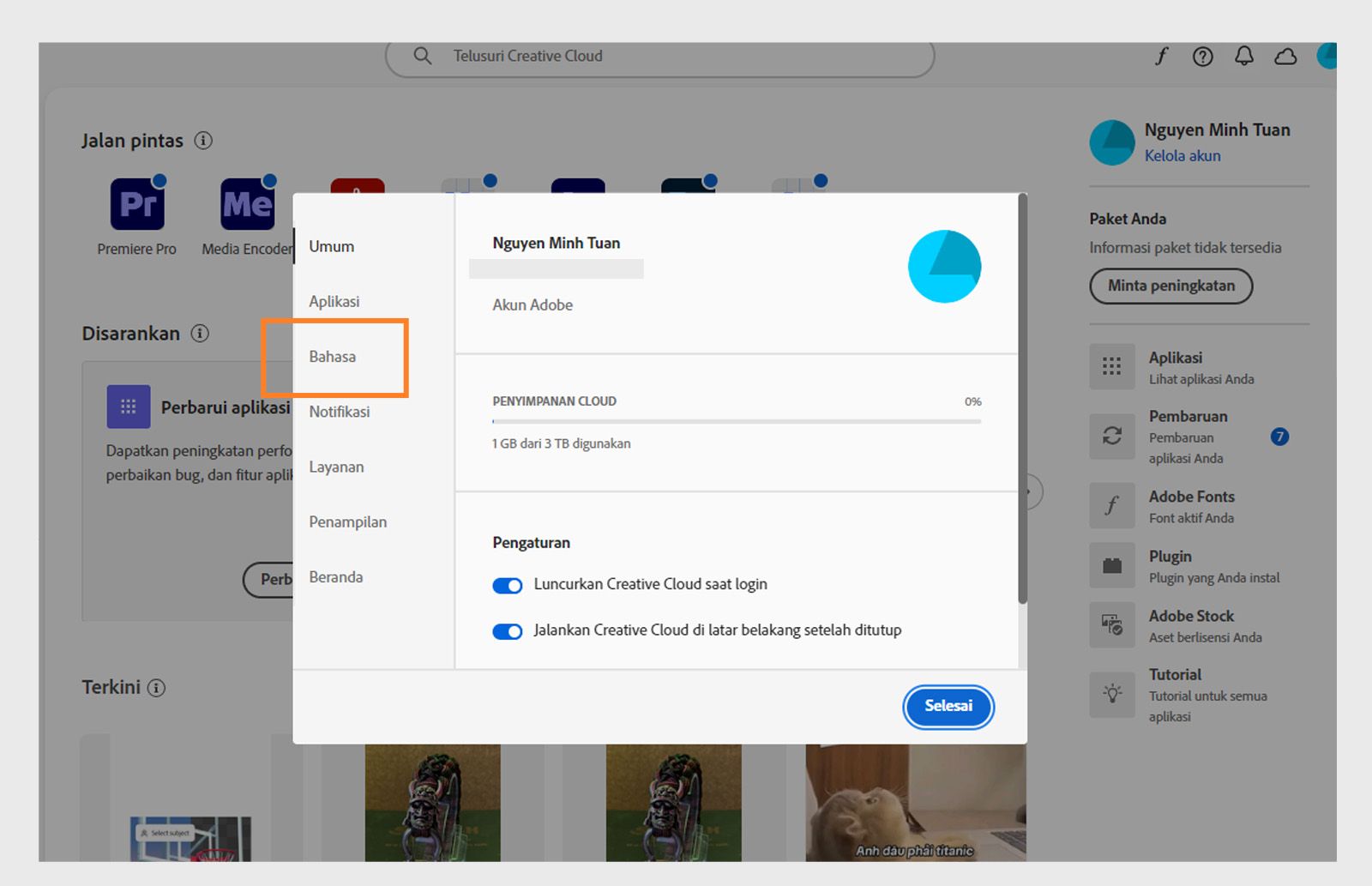 Panel preferensi Adobe Creative Cloud terbuka pada tab "Bahasa", menyoroti opsi untuk mengatur bahasa instalasi aplikasi default.