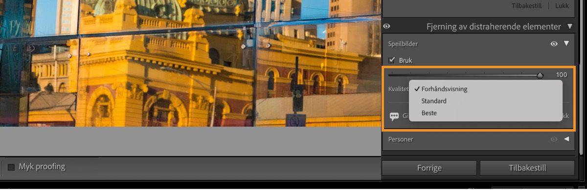 Skjermbilde av grensesnittet til programvaren for bilderedigering. Du ser et bymiljø reflektert i glassvinduer. Refleksjonen viser gule og oransje bygninger med søyler og buer. I panelet «Fjerning av distraherende elementer» på høyre side er «Refleksjoner» merket av med kvaliteten satt til 100 og alternativer for «Forhåndsvisning», «Standard» og «Best». Under panelet finner du knappene «Forrige» og «Tilbakestill».
