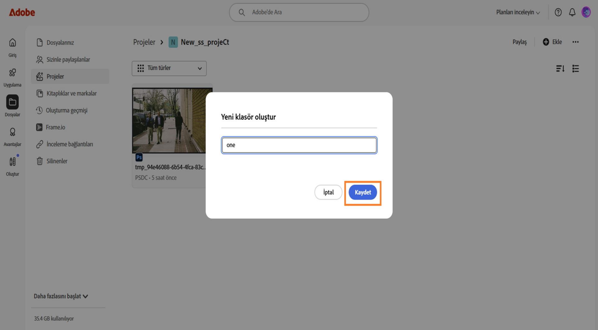 Adobe web arayüzünde "Yeni klasör oluştur" başlıklı bir iletişim kutusu gösteriliyor; klasör adını girmek için bir metin alanı ve iptal etme veya kaydetme seçenekleri bulunuyor.
