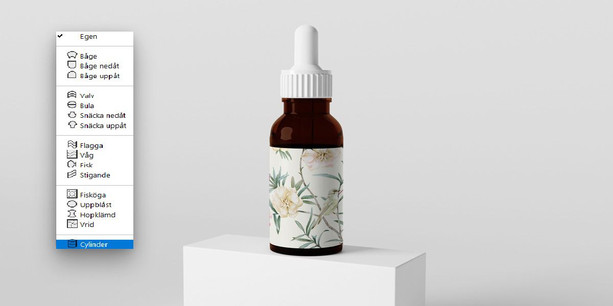 Photoshop tänj-menyn med Cylinder vald, visar en blommig etikett lindad runt en droppflaska.En flaska med dropp-pip.